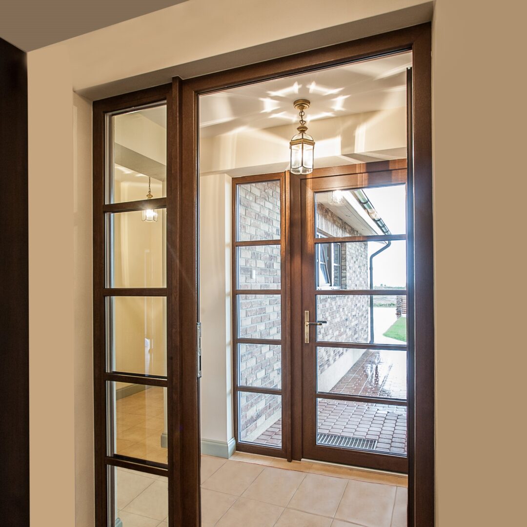 Taq-Door-S9000-Ușă dublă din lemn cu panouri de sticlă care duce la o intrare în aer liber, cu un design cald, clasic.